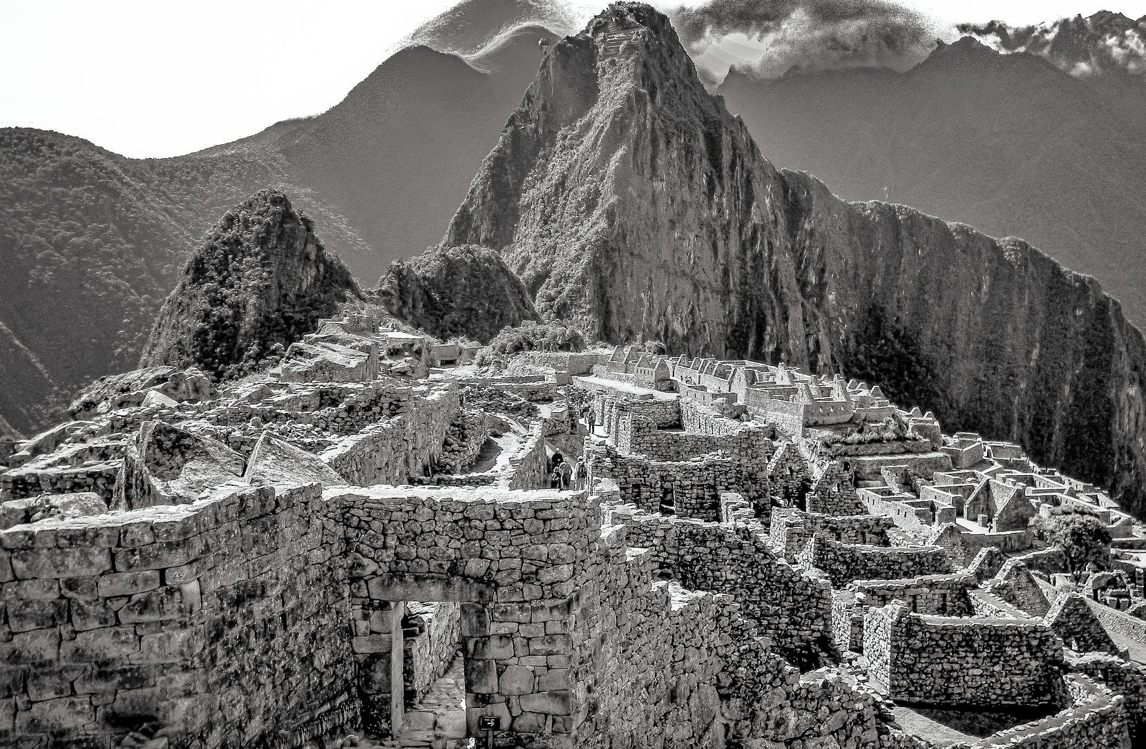 Black-and-white view of Machu Picchu's stone terraces and surrounding mountains